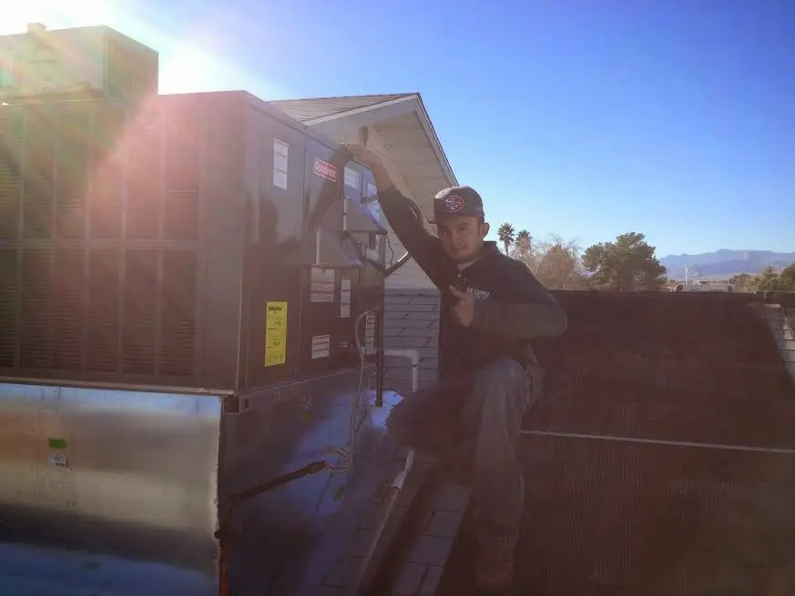 HVAC technician performing HVAC Inspection on a rooftop unit in Blakely